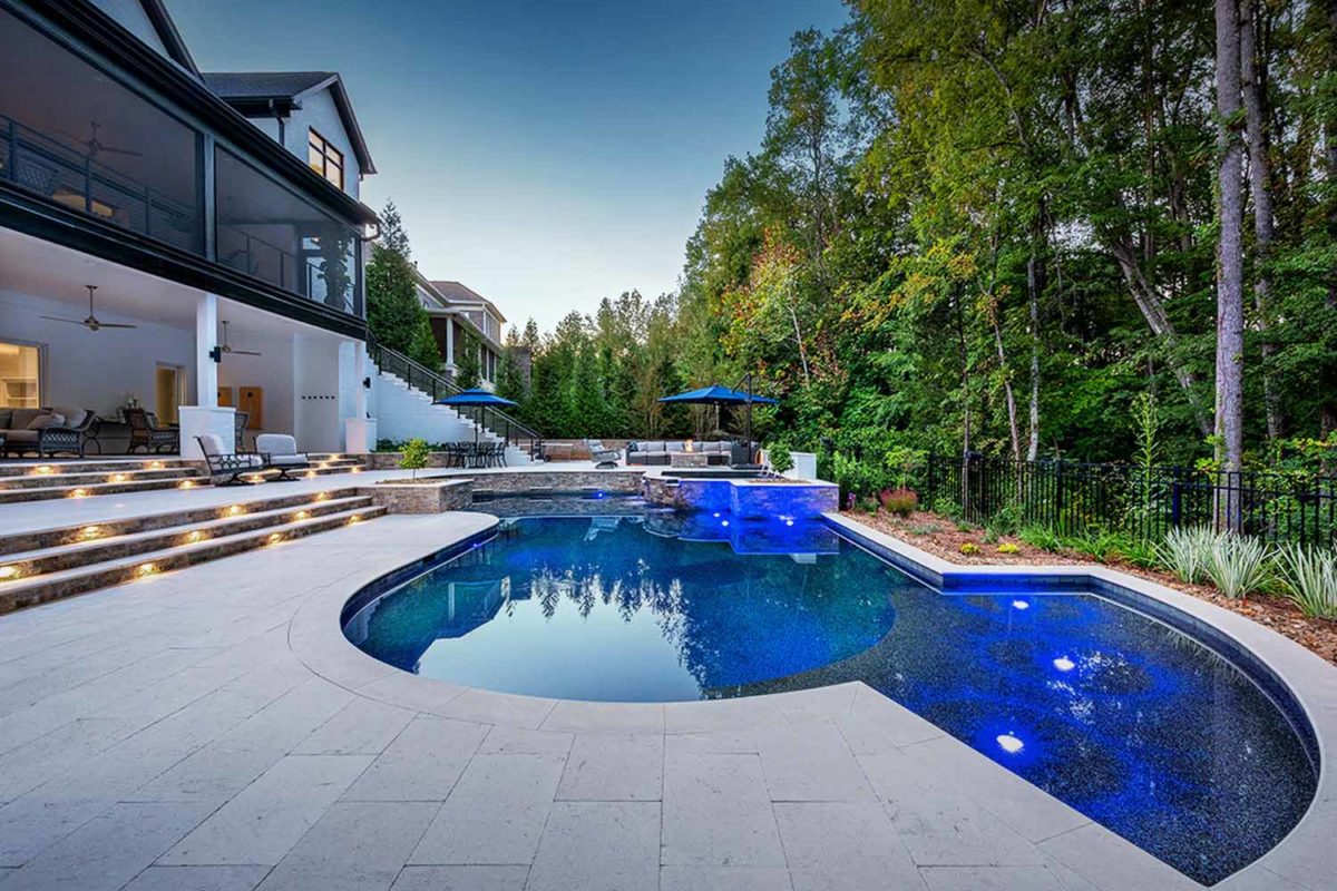 photo of a backyard pool design in PebbleTec Black Marble Pool Finish: A rich blend of white pebbles and a subtle metallic luster produce a deep dark blue water color.