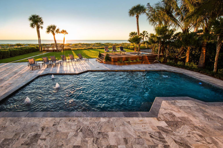 photo of PebbleTec PebbleBrilliance Crystal Harbor Pool Finish in a backyard with a sunset