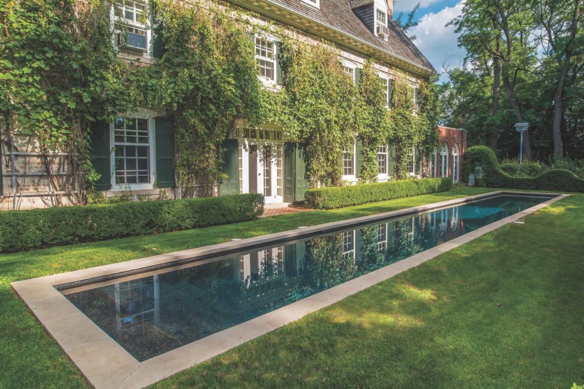 photo of a long lap pool in a serene backyard in PebbleTec Black Pearl Pool Finish dark blue water color