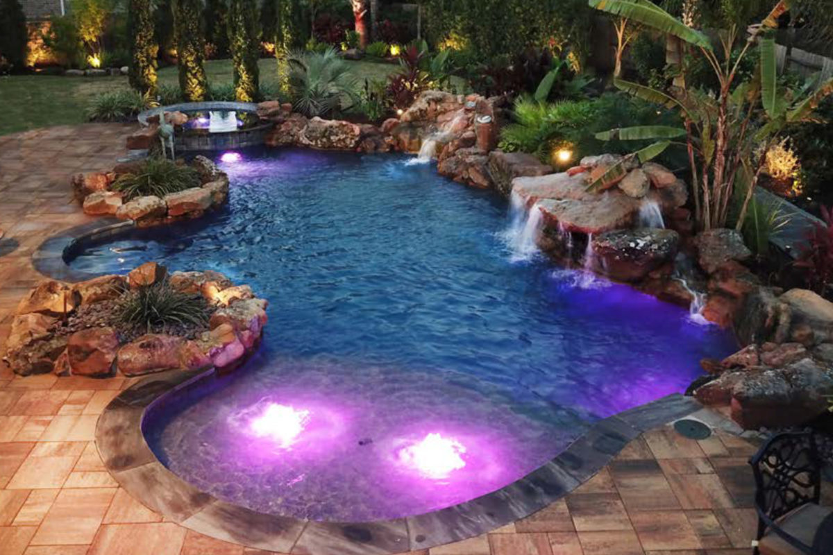 photo of a rocky backyard pool design in PebbleTec Blue Lagoon Pool Finish medium blue water color for World's Greatest Pools 2018