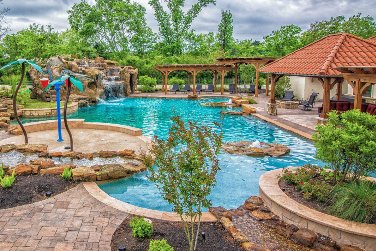 photo of a resort island style backyard pool design in PebbleTec Caribbean Blue Pool Finish medium blue water color