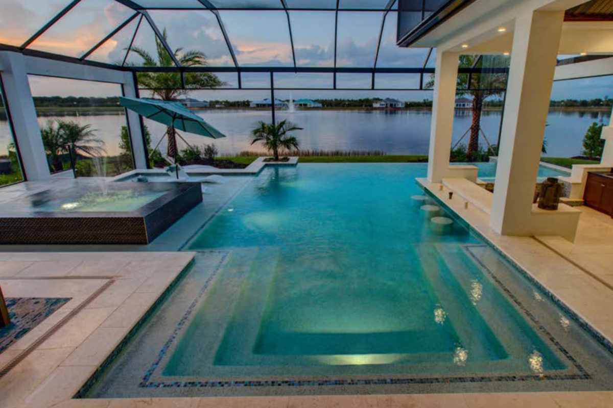photo of an enclosed indoor backyard pool on a lake in PebbleTec White Pearl Pool Finish light blue water color for World's Greatest Pools 2018