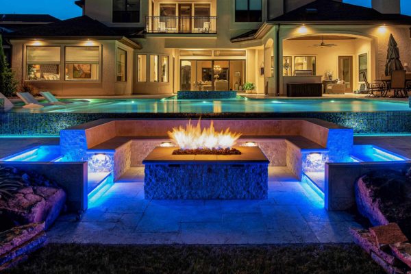 photo of a mansion backyard design with Pebble Sheen Seafood Green Regal Pool Finish and fire feature